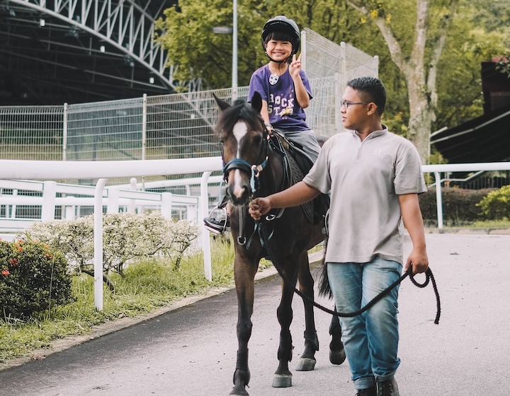 horse riding in singapore - singapore turf club riding centre - boy on a horse