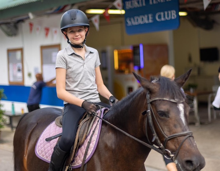 horse riding in singapore - bukit timah saddle club - girl riding a horse